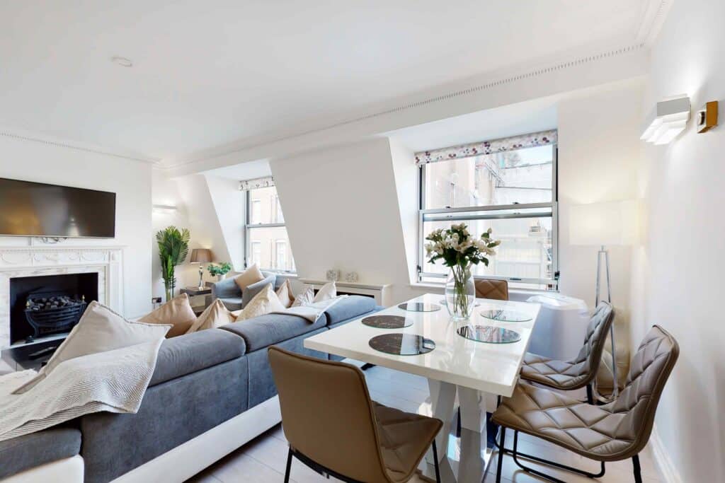 Crawford Place living and dining room with a cream sofa and a dining table by the windows