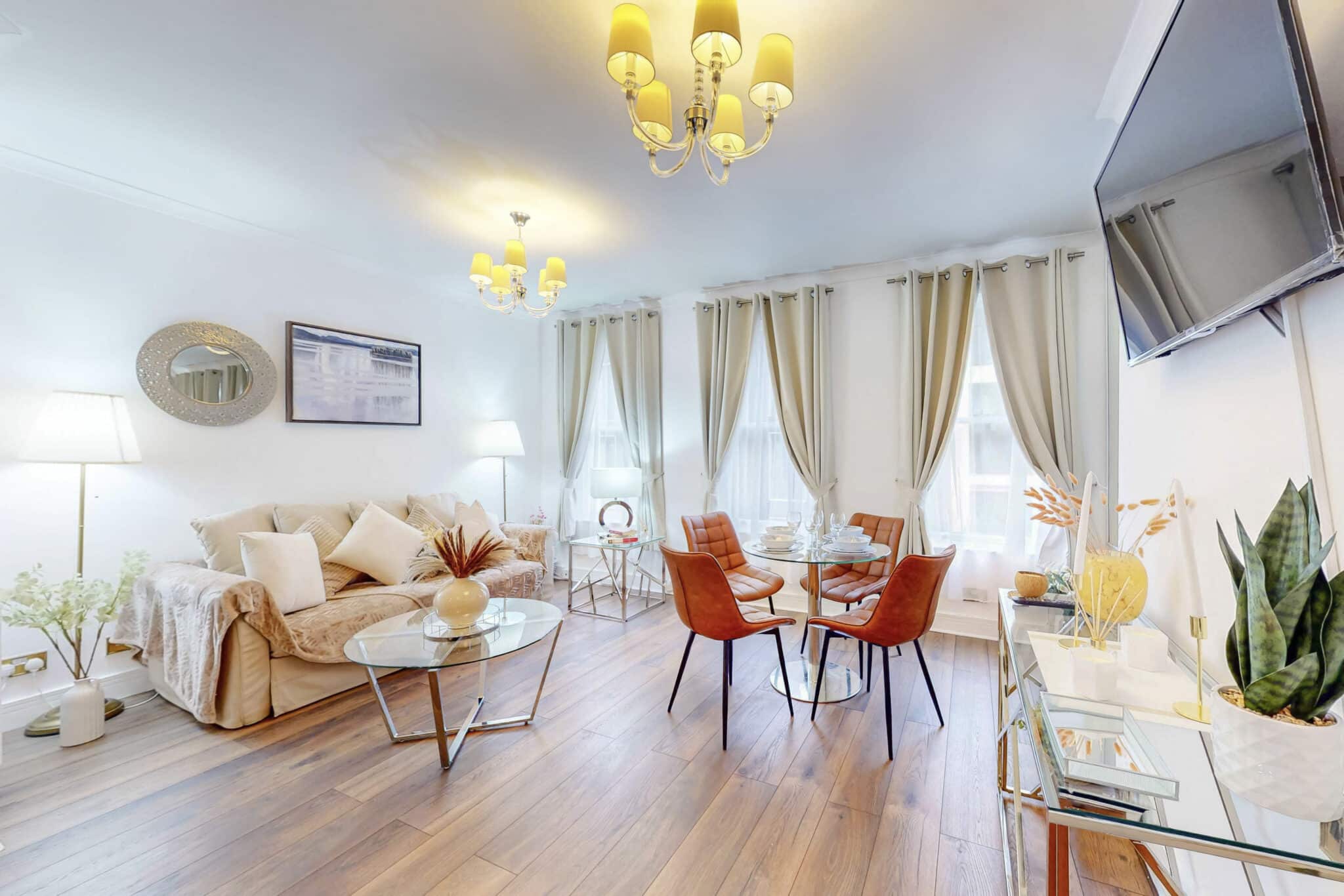 Sitting and dining room with a cream sofa and orange dining chairs at Mayfair Collection 37 Clarges Street