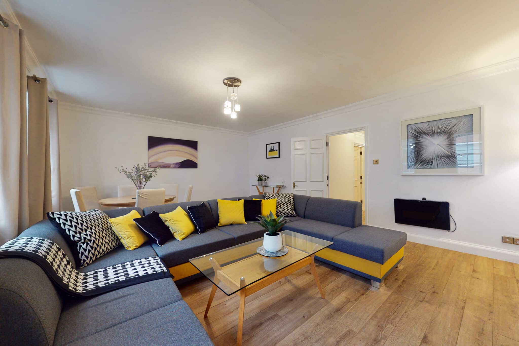 Living room with a grey corner sofa and a glass coffee table at Mayfair Collection 37 Clarges Street