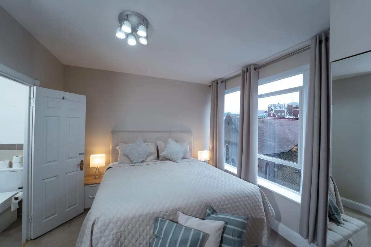 Double bedroom with a tall curtained window at Crawford Place Marylebone