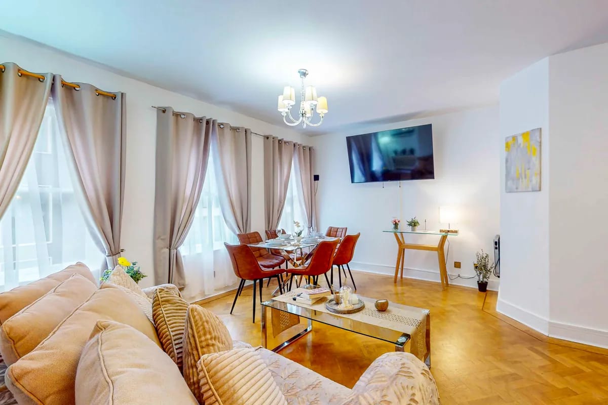 Sitting and dining room with a cream sofa and orange dining chairs at Mayfair Collection 37 Clarges Street