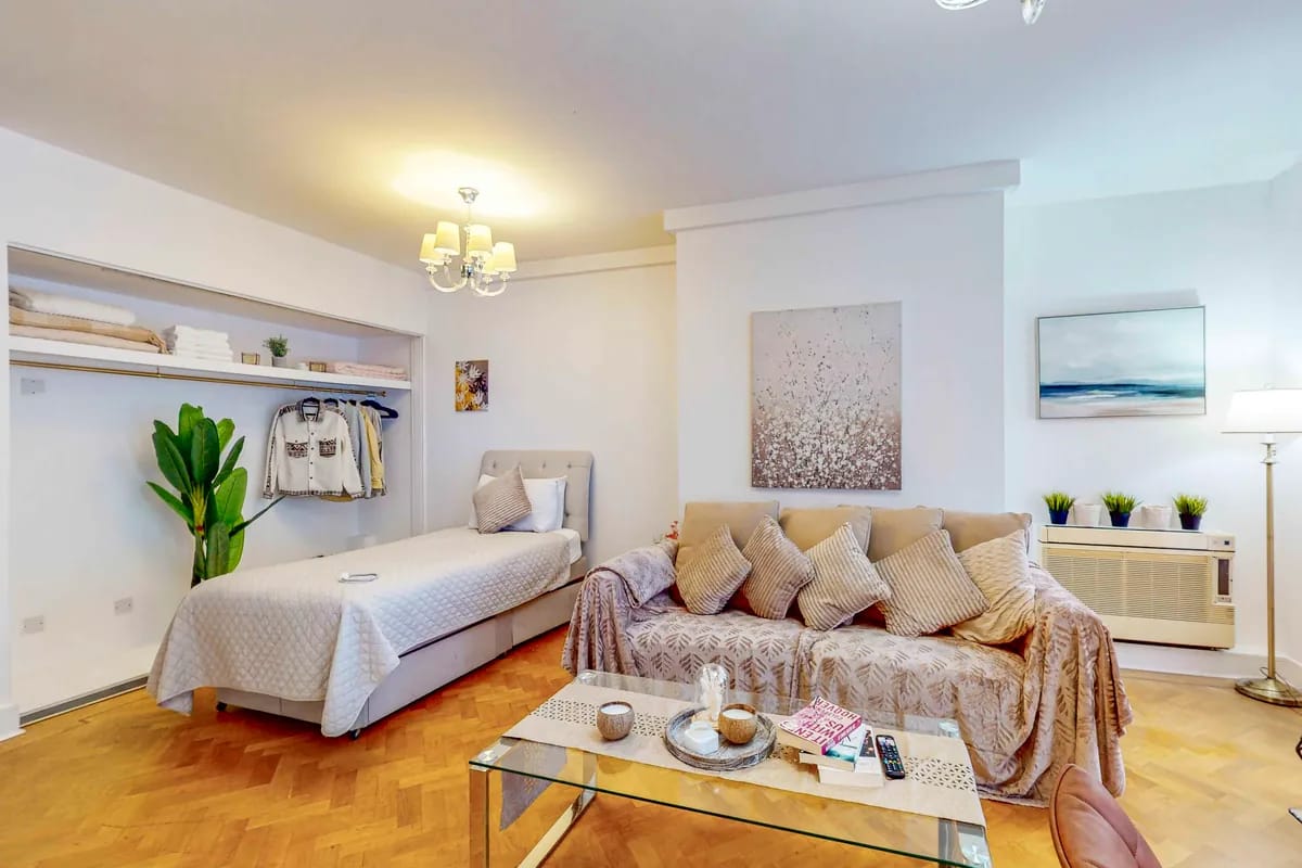 Living room with a sofa, a glass coffee table and a single bed at Mayfair Collection 37 Clarges Street